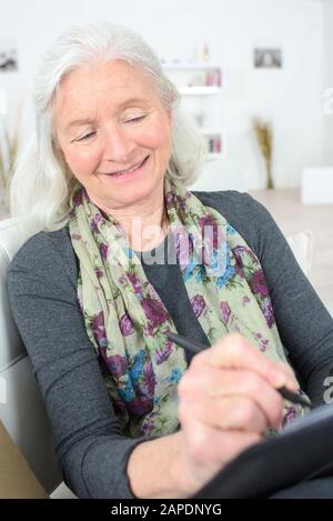 femme âgée à la maison écrire Banque D'Images