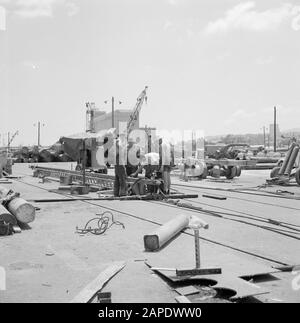 Israël 1964-1965: Haifa, port Description: Les travailleurs se replient sur une grue posée au sol Annotation: En arrière-plan le bâtiment caractéristique silo à grains de Dagon (voir ISR-2361) Date: 1964 lieu: Haifa, Israël mots clés: Travailleurs, activité, grues, quais Banque D'Images