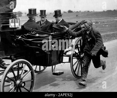Beggar à côté du transport du roi anglais George V (1865-1936). Epsom Downs, Derby Day, 1920. Banque D'Images