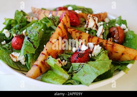 Assiette de salade verte avec poires rôties, fraises fraîches et fromage feta Banque D'Images