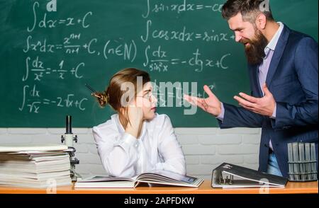 Situation de conflit. Conflit scolaire. Chargé de cours exigeant. Enseignant homme barbu strict ayant un conflit avec la fille étudiante. Homme mécontent de communiquer. Le directeur de l'école parle de punition. Banque D'Images