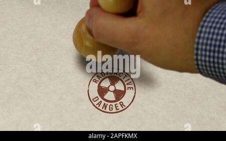 Symbole de danger radioactif estampille et main de marquage. Concept d'avertissement d'énergie atomique, d'alerte aux radiations et de risque d'énergie nucléaire. Banque D'Images