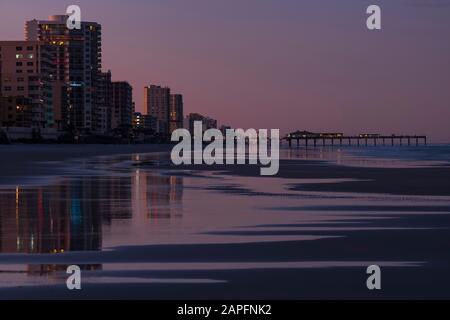 Les condominiums bordent l'océan à Daytona Beach, en Floride, le long de la côte atlantique après le coucher du soleil. Banque D'Images