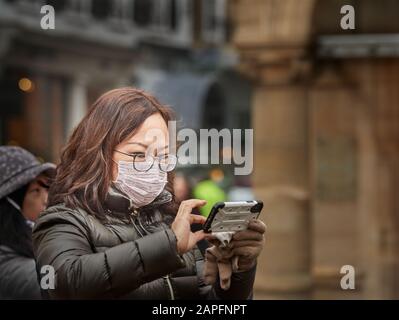 Masque anti-coronavirus porté par un touriste chinois en dehors de Trinity College, université de Cambridge, Angleterre, Royaume-Uni, menace le 22 février 2020. Banque D'Images