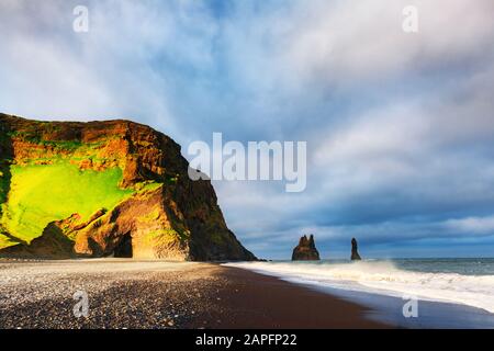 Vue incroyable sur la plage noire et les falaises de Troll orteils par temps nuageux. Reynisdrangar, Vik, Islande. Photographie Landswcape Banque D'Images