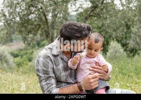 Père embrassant fille de bébé dans le jardin, Florence, Italie Banque D'Images
