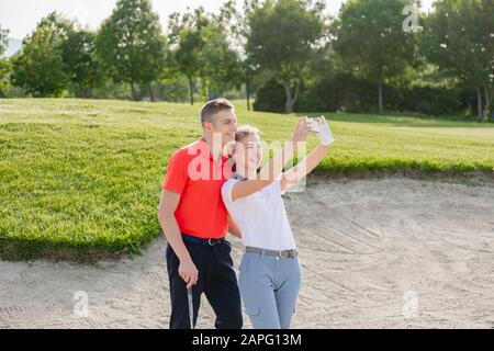 Couple prenant selfie sur le terrain de golf Banque D'Images