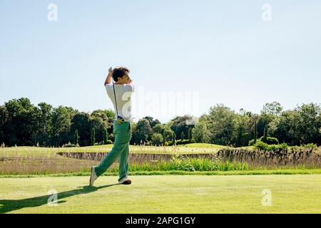 Man playing golf on golf course Banque D'Images