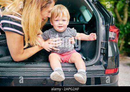 Mère assise bébé garçon à l'arrière du véhicule Banque D'Images