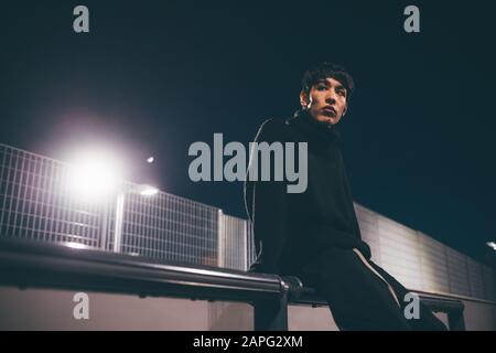 Man leaning against railing en attente, Milan, Italie Banque D'Images