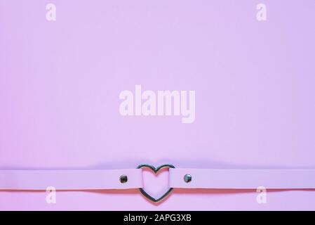 Chancre en cuir rose avec coeur en métal. Concept Saint Valentin Banque D'Images