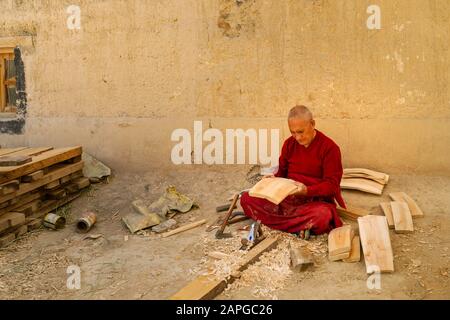 Moine bouddhiste assis et faisant le baril de bois avec des outils métalliques au monastère de Kaza, Himachal Pradesh, Inde. Banque D'Images