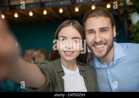 Un jeune couple heureux qui fait un drôle de selfie Banque D'Images