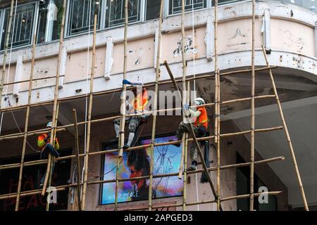 Hong Kong, novembre 2019: Travailleurs sur le chantier de construction de l'échafaudage en bambou sur la façade de maison à Hong Kong Banque D'Images