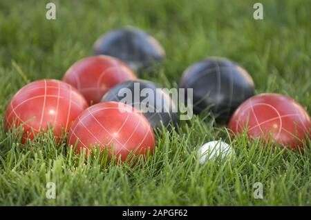 Photo de boules de bocce colorées sur la pelouse sous le lumière du soleil avec un arrière-plan flou Banque D'Images