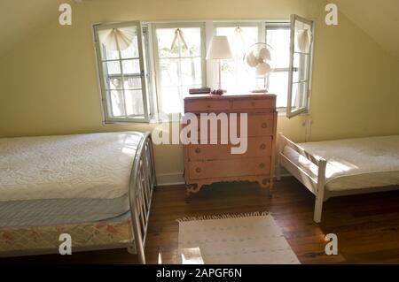 Chambre à l'ancienne avec deux lits et un placard la lumière du soleil des fenêtres Banque D'Images