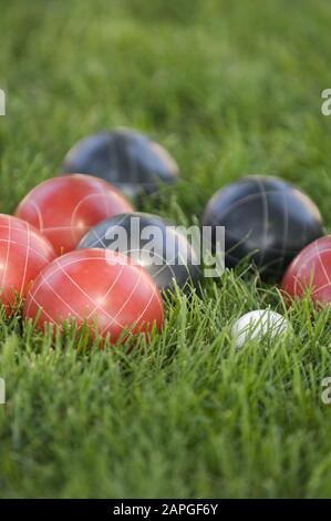 Image verticale de boules de bocce colorées sur la pelouse sous la lumière du soleil avec un arrière-plan flou Banque D'Images