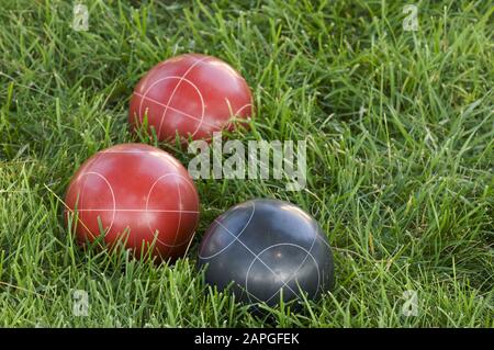 Image verticale des boules de bocce colorées sur la pelouse sous la lumière du soleil Banque D'Images