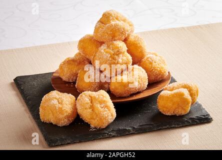 Carnaval frit Tortelli, un dessert saisonnier régional populaire, récolté sur une plaque sur une serviette pliée de Lombardie, Italie Banque D'Images