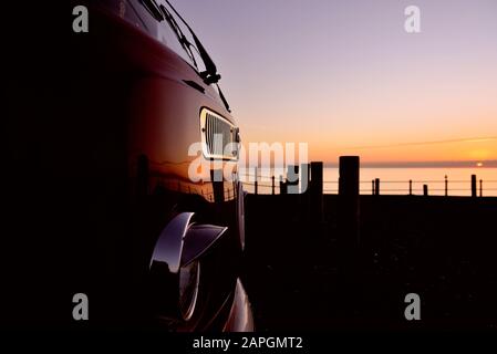 Un camionnette VW Volkswagen garée au lever du soleil / coucher du soleil. Hastings, East Sussex, Angleterre, Royaume-Uni Banque D'Images