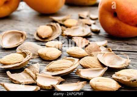 Abricots près de fosses et de fosses d'abricots sur le fond de vieux planches. Abricots pour la fabrication de comprimés et de médicaments. Gros plan. Banque D'Images