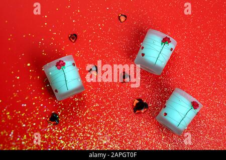 Aroma candles décoré de roses et coeurs sur fond rouge. Valentines Day. Banque D'Images