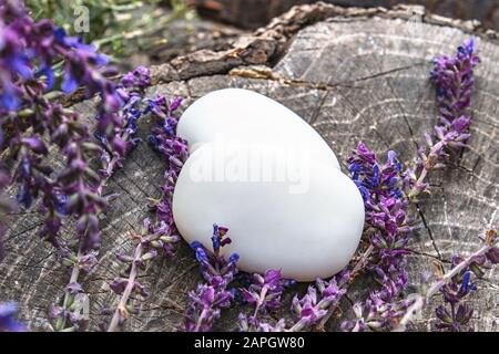 Morceaux de savon fait à la main avec des fleurs de champ de lavande sur un fond en bois. Savon pour le visage. Soins du corps. Banque D'Images