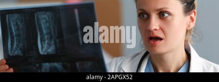 Excitée femme médecin tenir x-ray film dans la main contre Banque D'Images