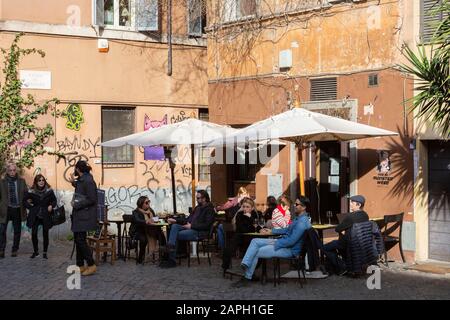 Les clients s'assoient à l'extérieur d'une cafe dans le quartier Trastevere de Rome, en Italie Banque D'Images