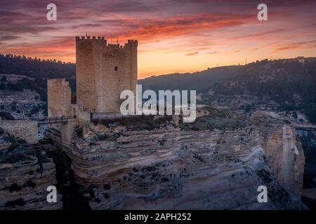 Coucher de soleil vue panoramique panoramique sur Alcala del Jucar village historique médiéval avec des maisons lavées de blanc et un château sur un rocher dans la province d'Albacete Castill Banque D'Images