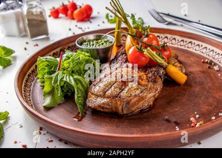 Entrecote de porc servi avec légumes grillés, champignons et sauce pesto, plat de restaurant, orientation horizontale Banque D'Images