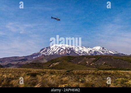 Hélicoptère en service public de nettoyage des toilettes en vol au-delà du mont Ruapehu, parc national de Tongariro, île du Nord, Nouvelle-Zélande, Banque D'Images