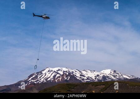 Hélicoptère en service public de nettoyage des toilettes en vol au-delà du mont Ruapehu, parc national de Tongariro, île du Nord, Nouvelle-Zélande, Banque D'Images