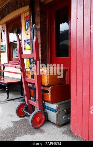 Vieux valises et chariot à bagages sur la plate-forme de la gare de la ville de Tenterden, chemin de fer Kent & East Sussex, Tenterden, Kent, Angleterre Banque D'Images