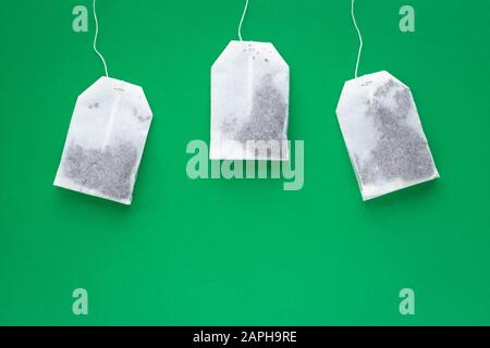 Trois sachets de thé blanc sur fond vert avec espace de copie Banque D'Images