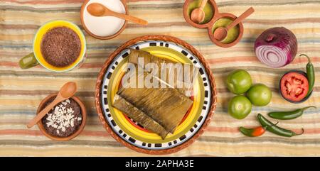 Tamales Oaxaqueños, plat mexicain fabriqué avec de la pâte de maïs, du poulet ou du porc et du piment, enveloppé dans des feuilles de banane. Banque D'Images