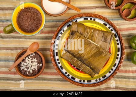 Tamales Oaxaqueños, plat mexicain fabriqué avec de la pâte de maïs, du poulet ou du porc et du piment, enveloppé dans des feuilles de banane. Banque D'Images