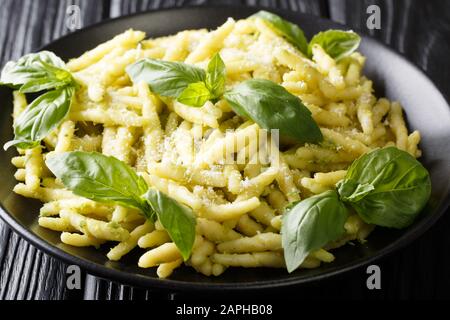 Recette de pâtes trofie avec pesto de basilic et gros plan de parmesan dans une assiette sur la table. Horizontale Banque D'Images