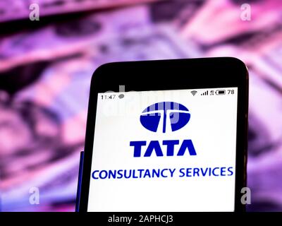 Dans cette illustration photo, le logo Tata Consultancy Services Limited est affiché sur un smartphone à l'arrière-plan des factures en dollars américains. Banque D'Images