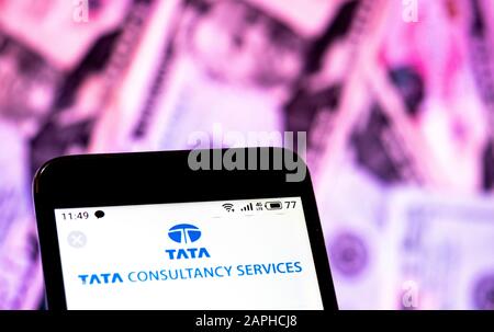 Dans cette illustration photo, le logo Tata Consultancy Services Limited est affiché sur un smartphone à l'arrière-plan des factures en dollars américains. Banque D'Images