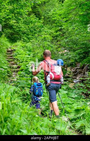 Junge Familie mit kleinen Kindern beim Wandern in den Bergen Banque D'Images