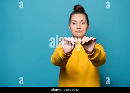 une fille dans un sweat-shirt jaune casse une cigarette dans la moitié, symbolisant l'abandon d'une mauvaise habitude. Mise au point sélective Banque D'Images