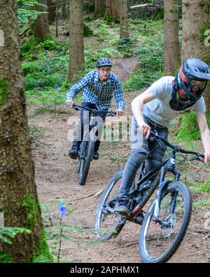 Riders vtt faisant un courageux en descente sur des sentiers en forêt Banque D'Images