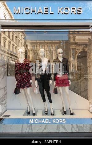 Florence, Italie - 2020, Jan 19: Vêtements, chaussures, sac et accessoires dans une boutique de mode Michael Kors. Paysage urbain reflété dans les fenêtres. Banque D'Images