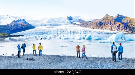 Paysage islandais. Panorama des touristes visitant le glacier de Fjallsarlon et le lagon au coucher du soleil. Banque D'Images