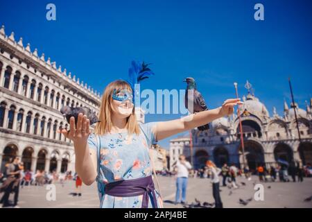 Portrait of smiling young woman in Venise, Italie en masque de Venise rss pigeons sur la Place St Marc. Voyage Concept Banque D'Images