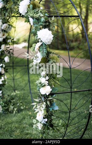 Belles fleurs blanches sur l'arche de cérémonie de mariage en métal pour le mariage extérieur Banque D'Images