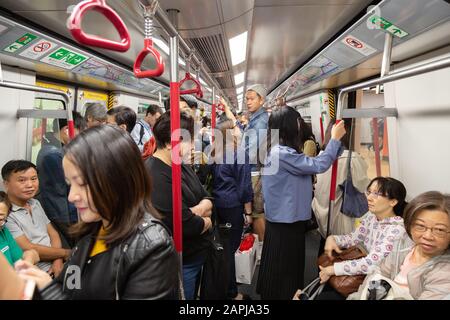 MTR ou Mass transit Railway de Hong Kong - passagers à l'intérieur d'un chariot debout et assis sur le système de transport public MTR, Hong Kong Banque D'Images