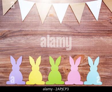 Carte de Pâques avec lapins et drapeaux de garland sur fond en bois Banque D'Images