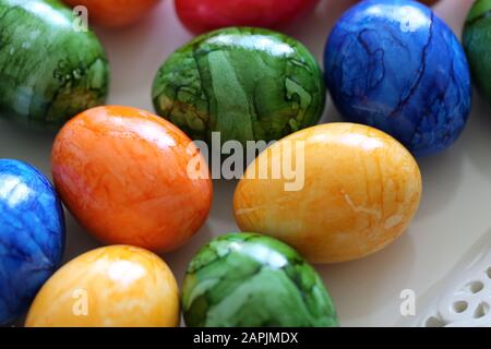 Des décorations de Pâques colorées et joyeuses sur une table. Gros plan image couleur de plusieurs oeufs de Pâques peints avec des couleurs vives et heureuses. Banque D'Images